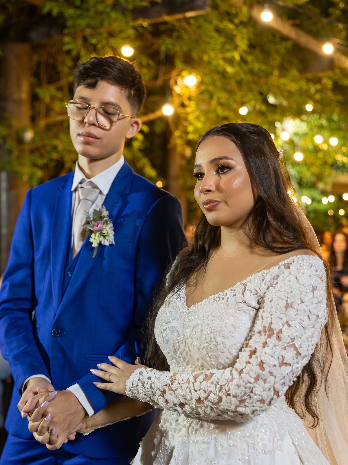 Casal de mãos dadas na cerimônia à noite